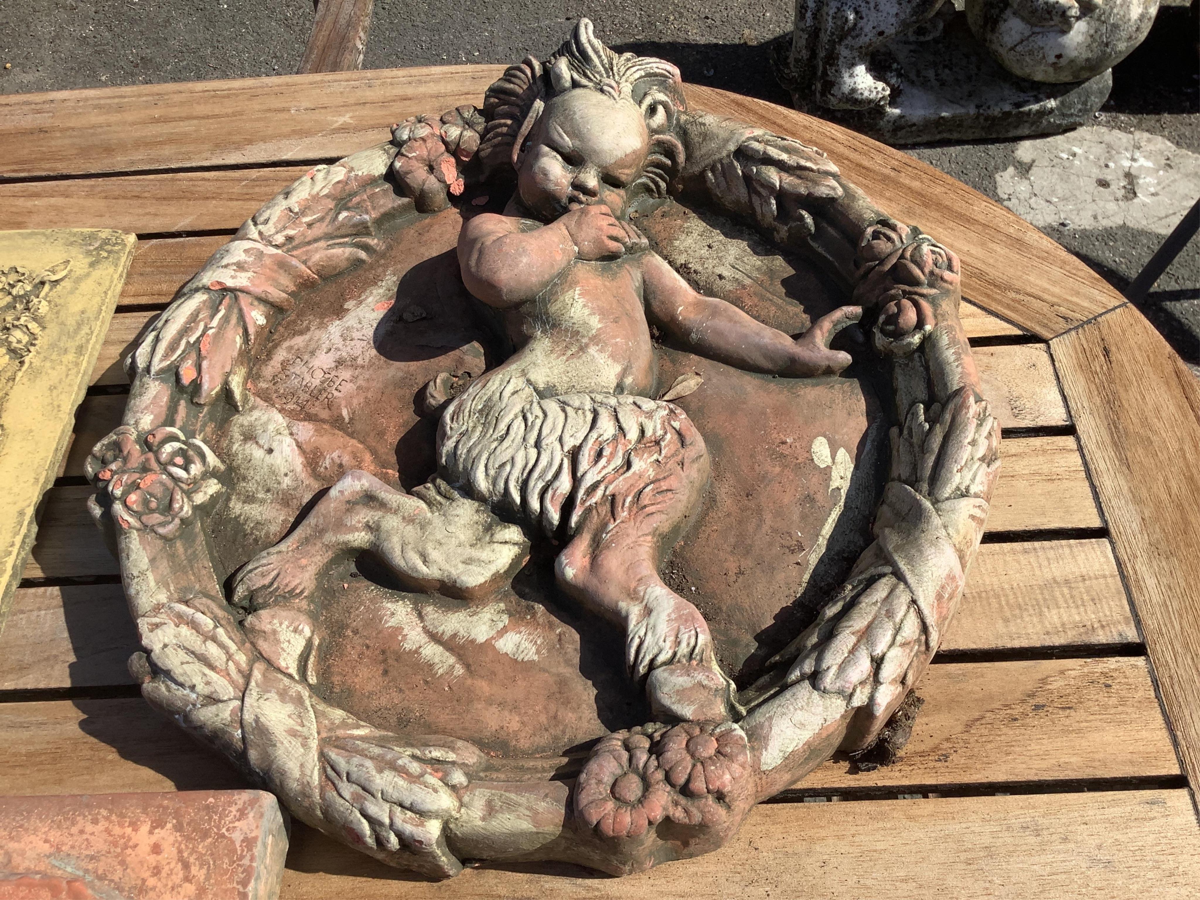 Five cast stone and terracotta garden wall plaques, largest diameter 41cm